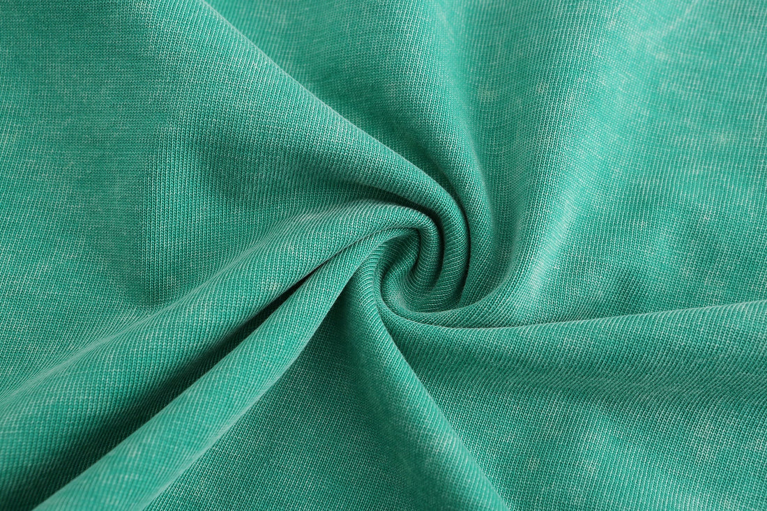 Close-up of green snow washed cotton fabric with swirled garment dye texture