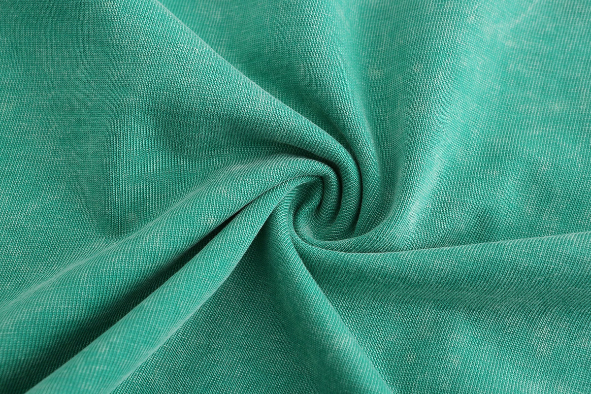 Close-up of green snow washed cotton fabric with swirled garment dye texture