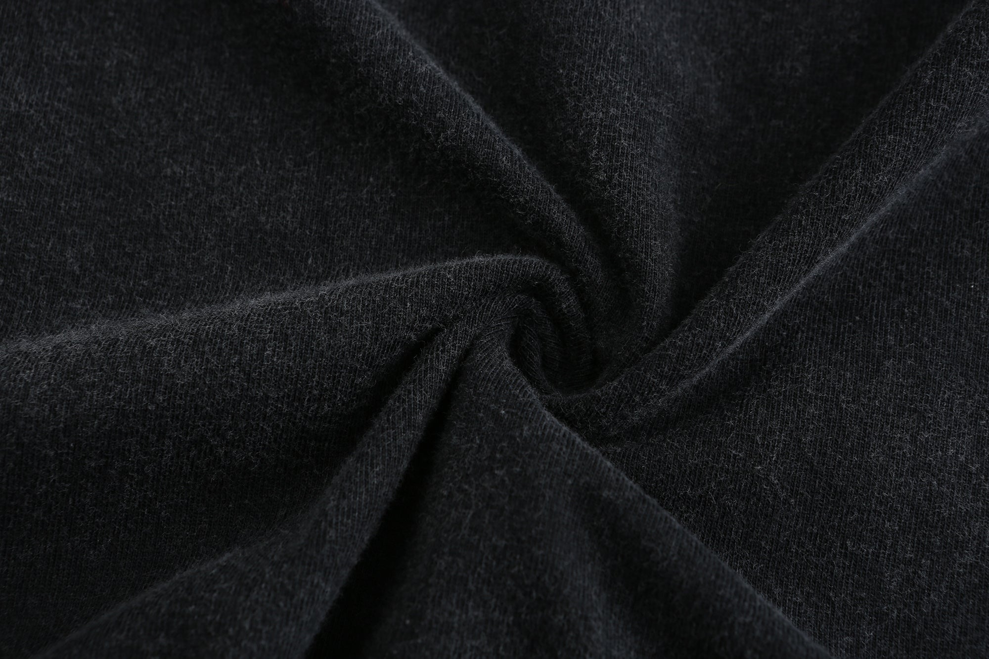 Close-up of black snow washed cotton jersey texture with uneven vintage dye variation