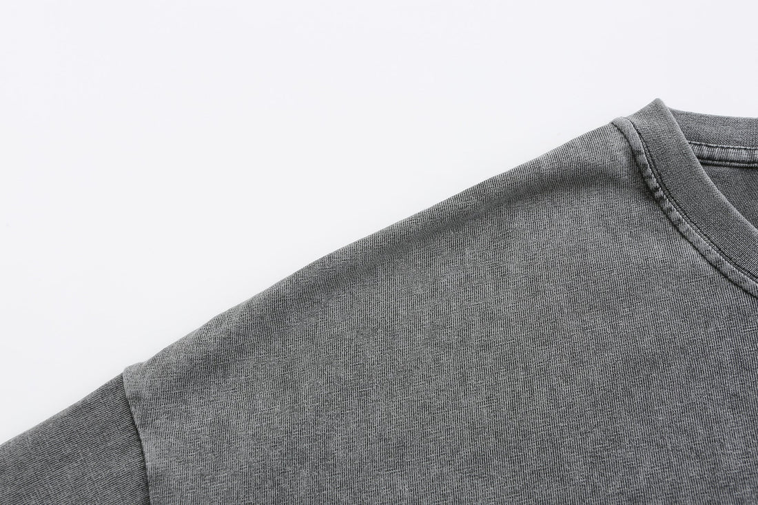 Gray vintage washed cotton T-shirt sleeve detail with visible fabric texture and seam finish