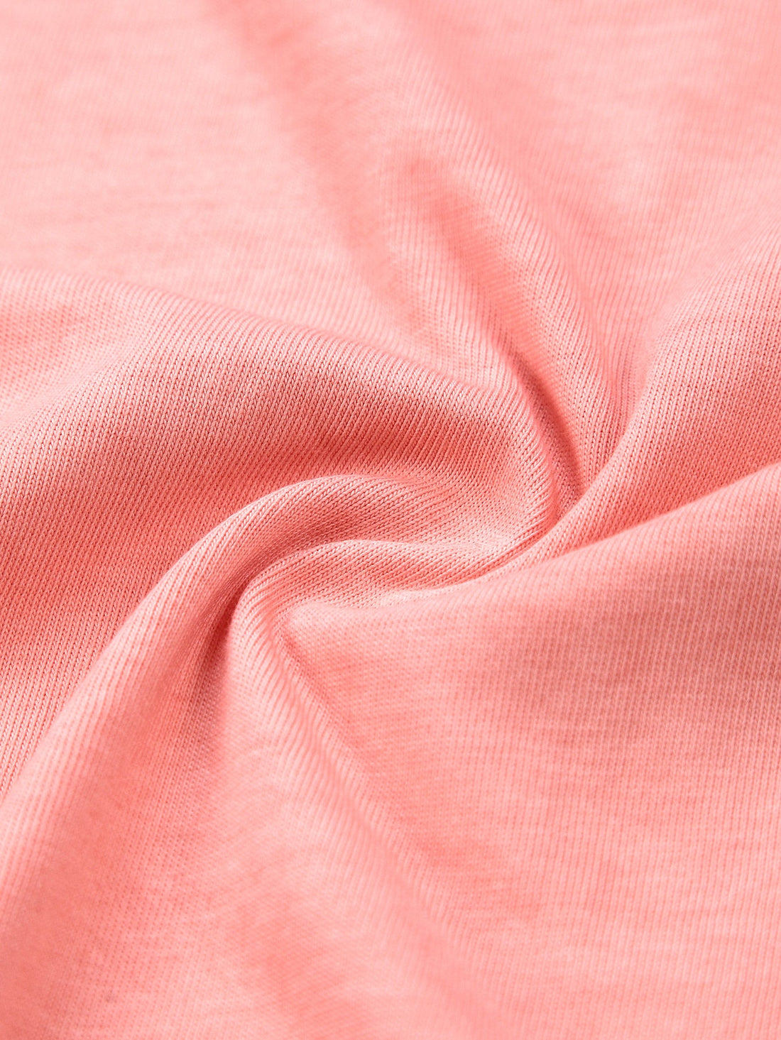Coral ombre washed cotton fabric close-up showing dye depth and soft jersey texture