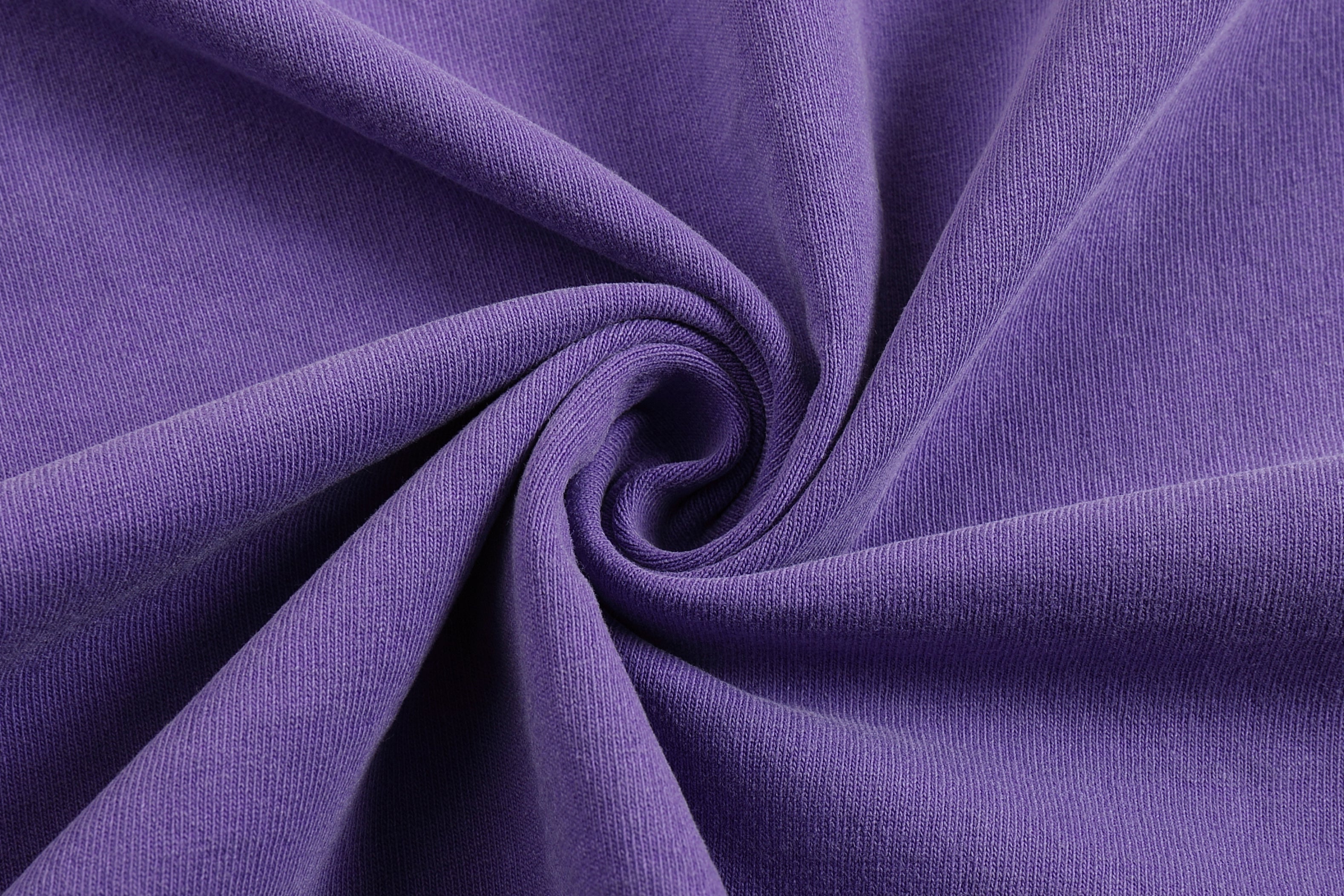 Purple pigment dyed cotton jersey fabric swirl showing vintage wash texture and color depth