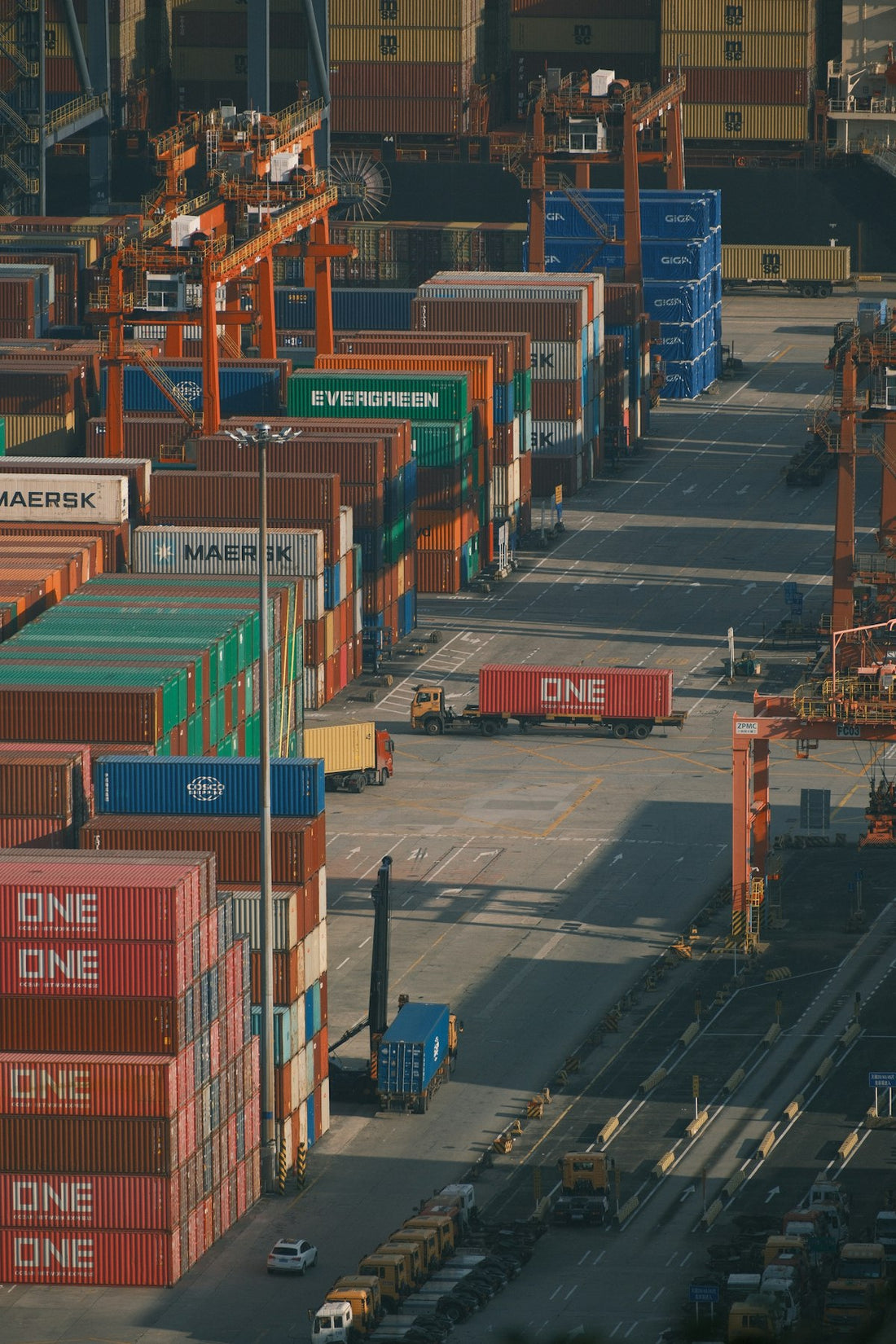 OEM vs ODM clothing manufacturing — shipping containers stacked at a busy freight port