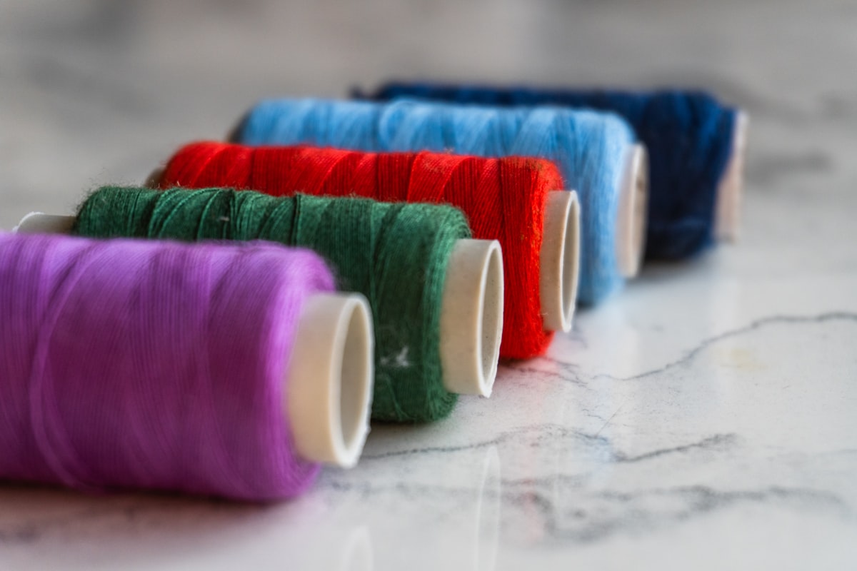 enzyme washing vs stone washing vintage cotton t-shirts — colorful thread spools for garment dyeing